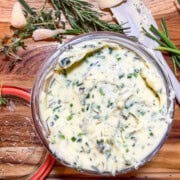 Herb butter with roasted garlic, fresh rosemary, thyme, and chives in a serving dish