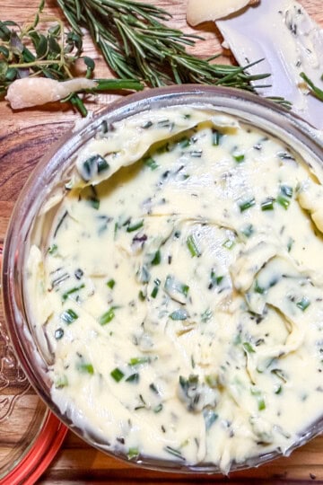 Herb butter with roasted garlic, fresh rosemary, thyme, and chives in a serving dish