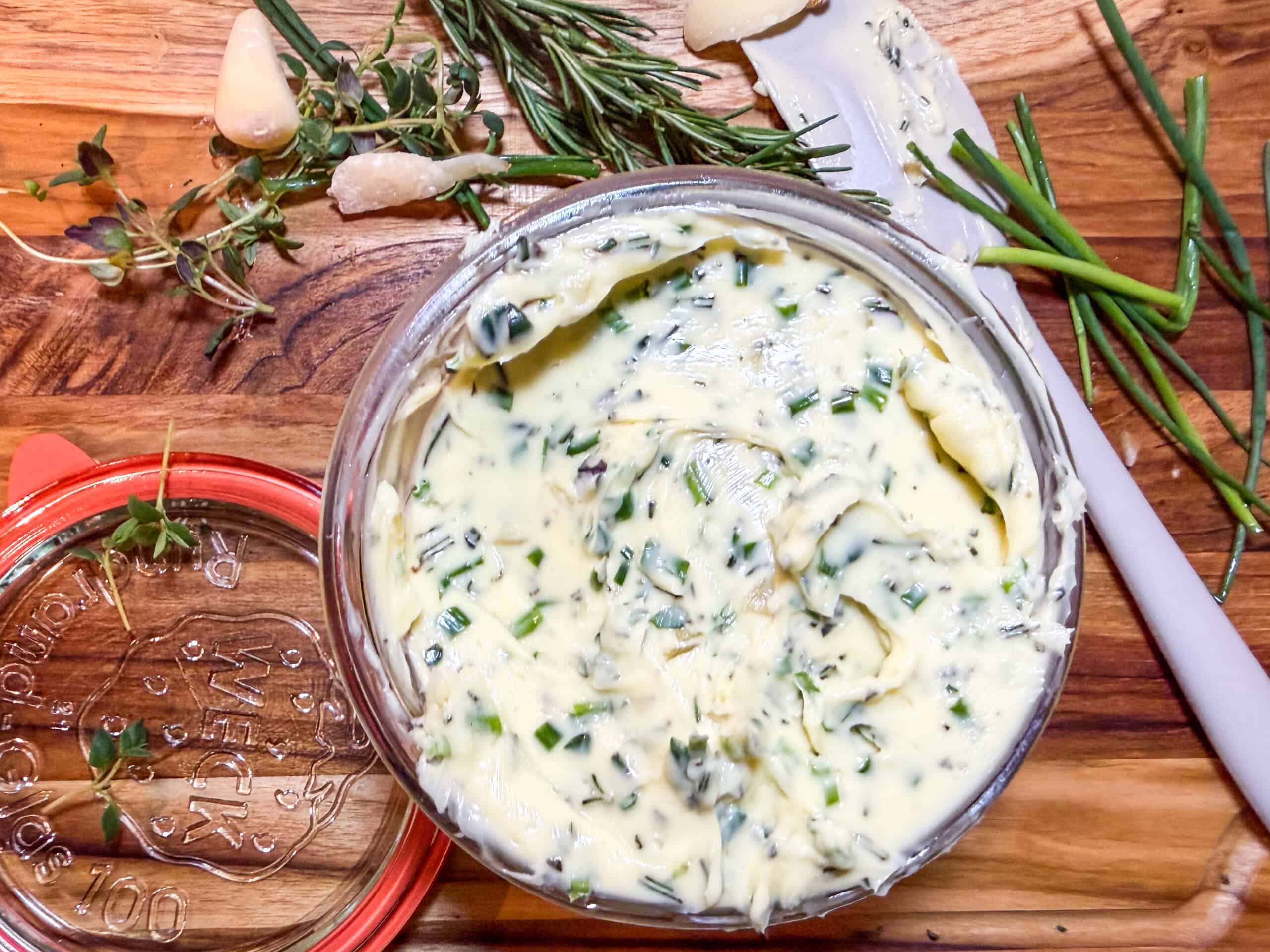 Herb butter with roasted garlic, fresh rosemary, thyme, and chives in a serving dish