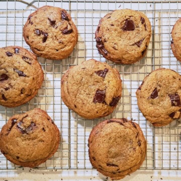Chewy chocolate chip cookies with melted chocolate chunks cooling on wire rack