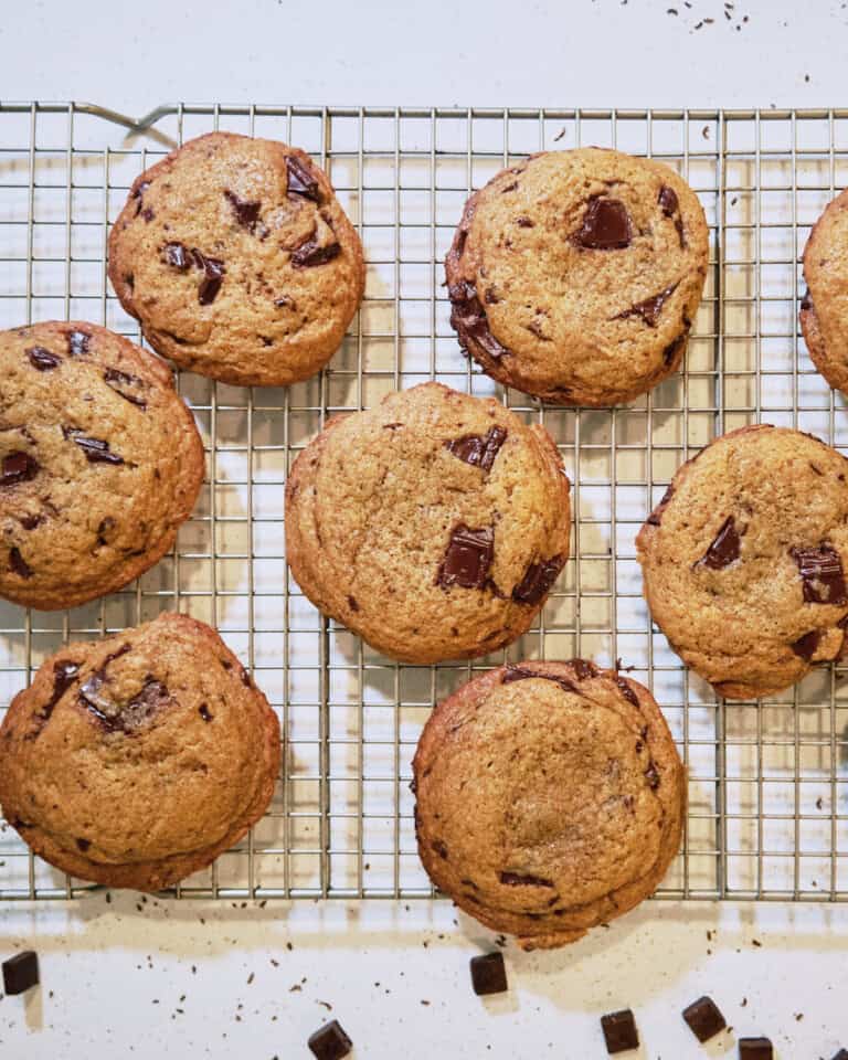 Chewy chocolate chip cookies with melted chocolate chunks cooling on wire rack